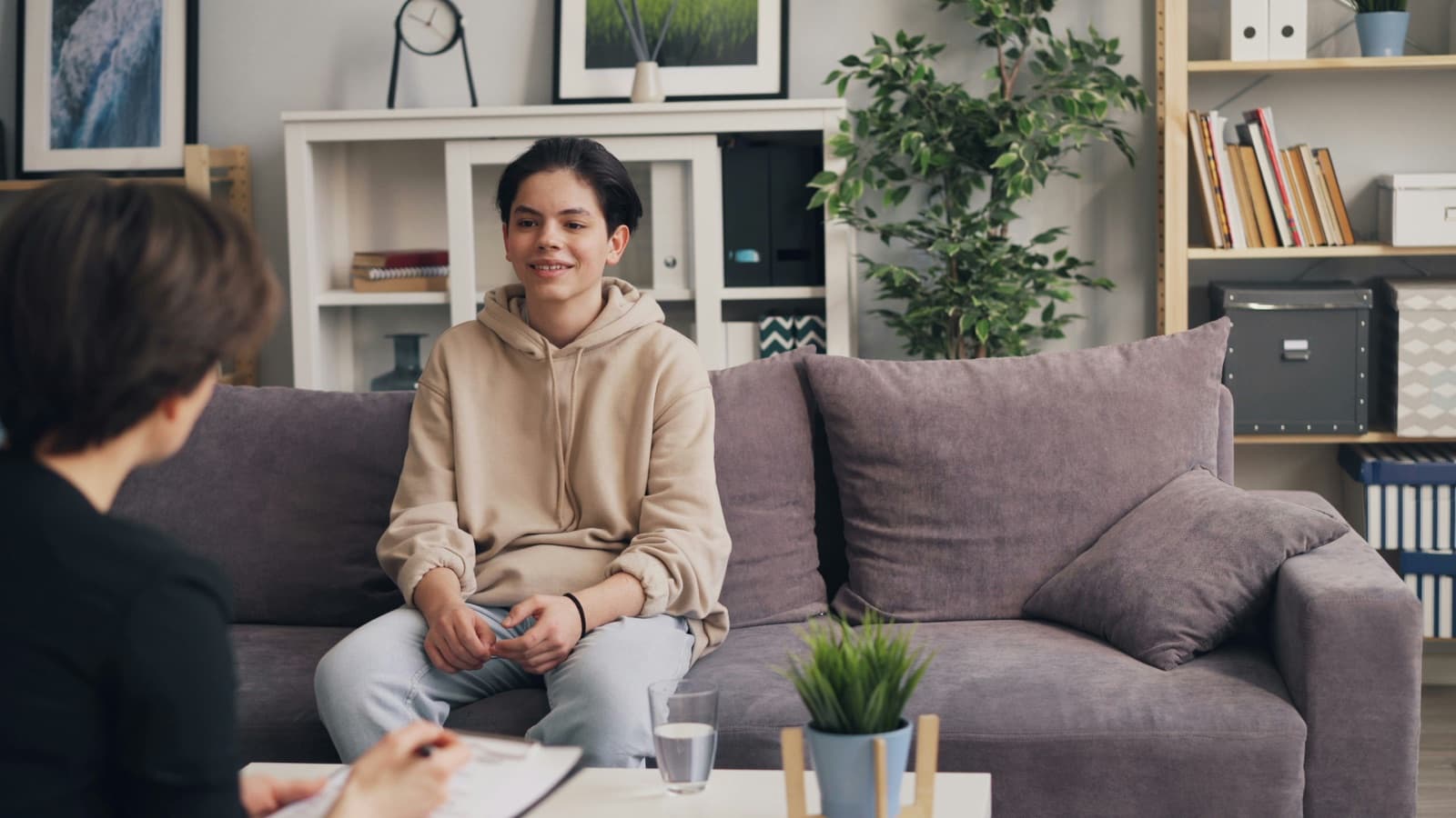 Two women sitting on a couch in conversation.